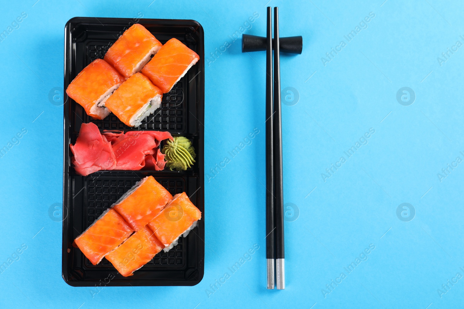 Photo of Flat lay composition with sushi rolls on color background, space for text. Food delivery