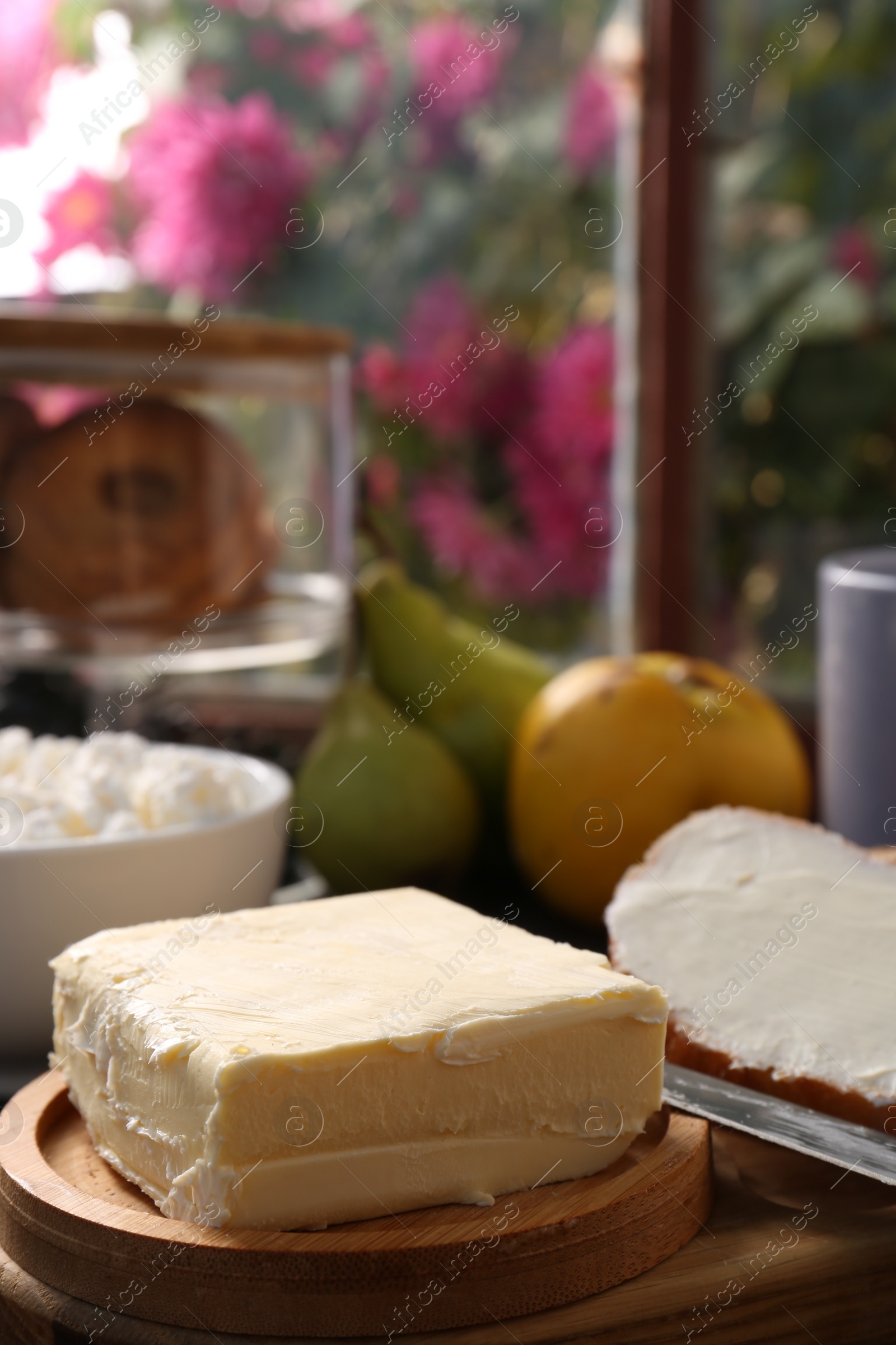 Photo of Tasty homemade butter, bread slices and tea on wooden table