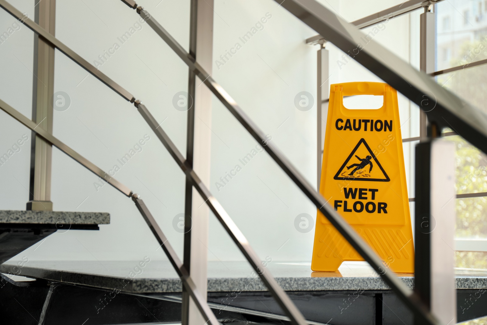 Photo of Safety sign with phrase Caution wet floor on stairs. Cleaning service