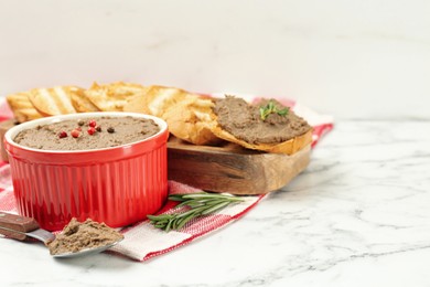 Photo of Tasty liver pate, rosemary and slices of bread on white marble table, space for text