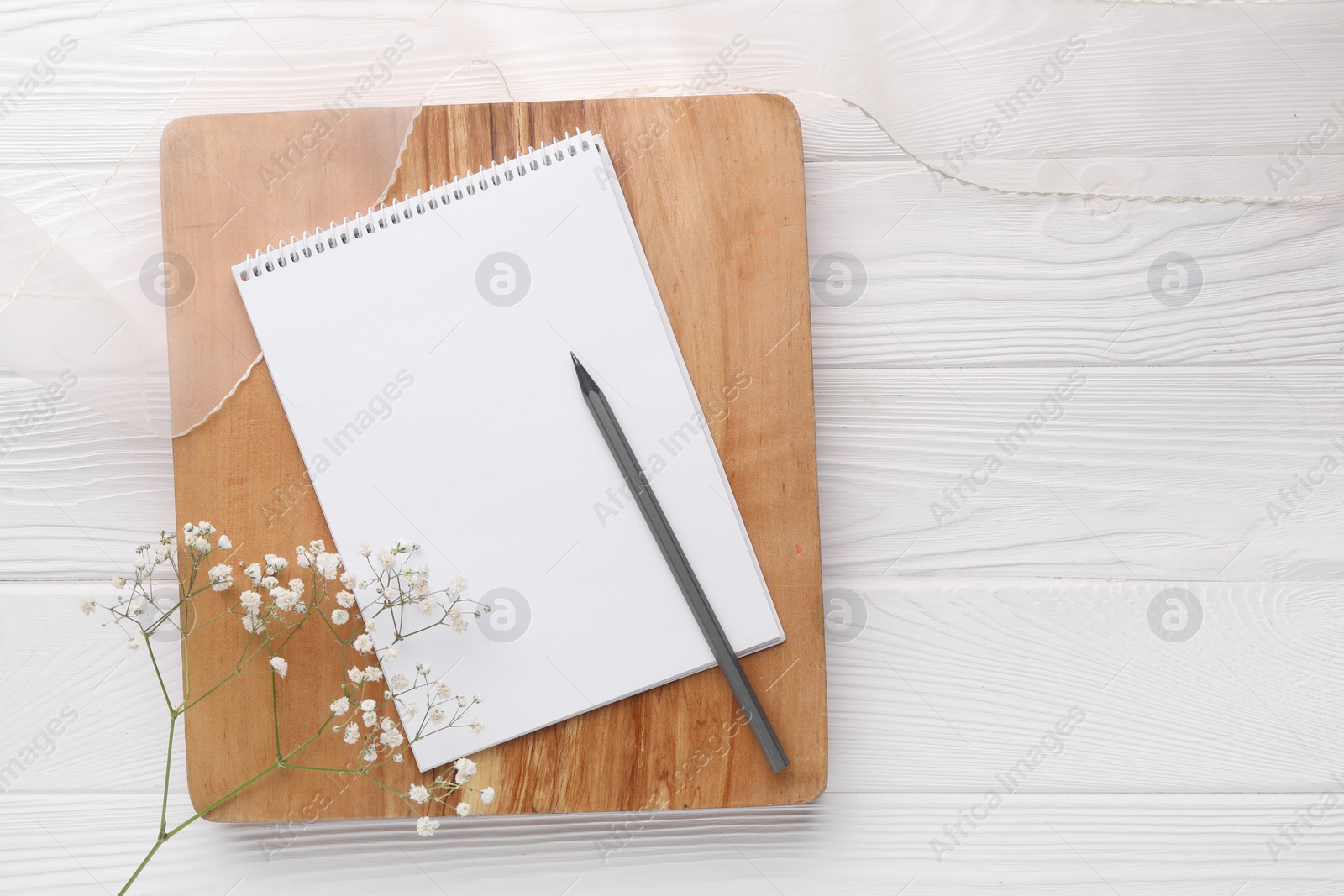 Photo of Guest list. Notebook, pencil, gypsophila and ribbon on white wooden background, flat lay. Space for text