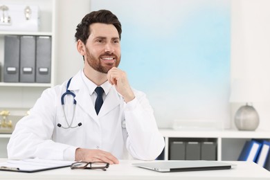 Photo of Medical consultant with stethoscope at table in clinic, space for text