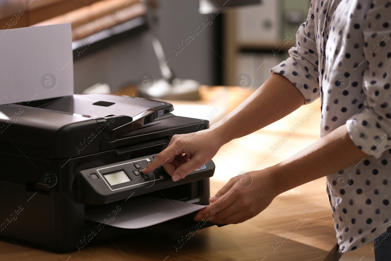 Photo of Employee using modern printer in office, closeup