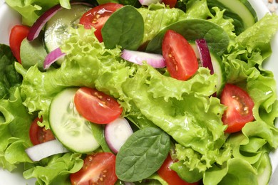 Top view of delicious salad in white bowl, closeup