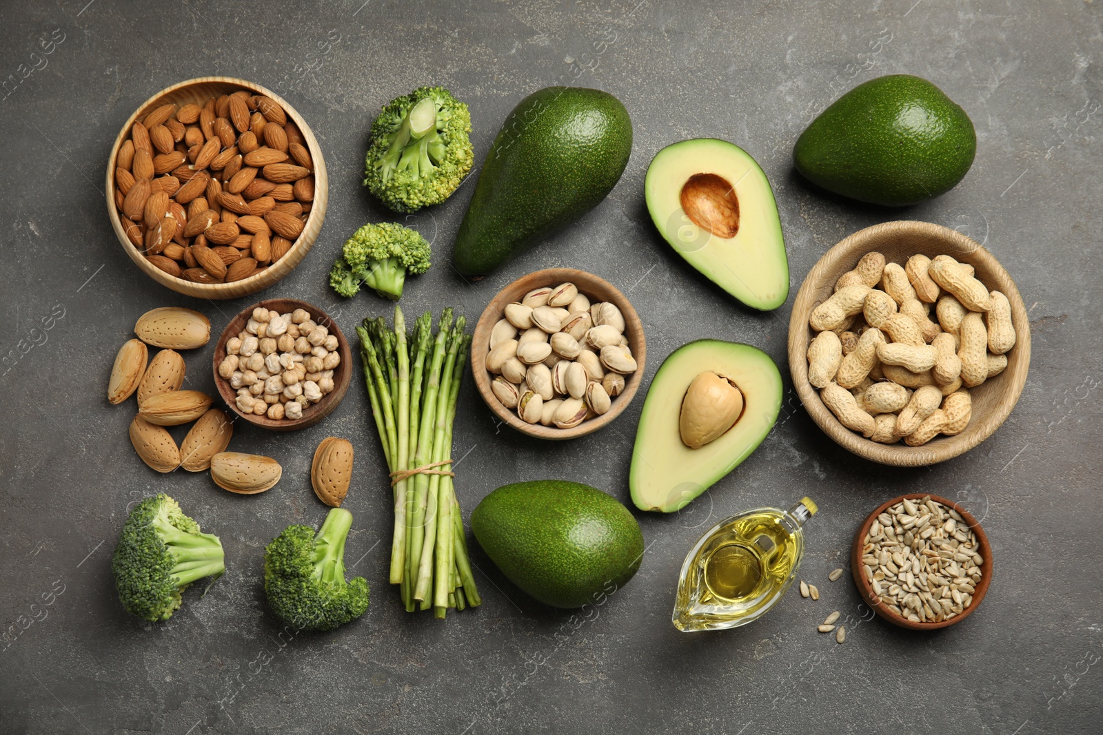 Photo of Different products rich in vitamin E on grey background, flat lay