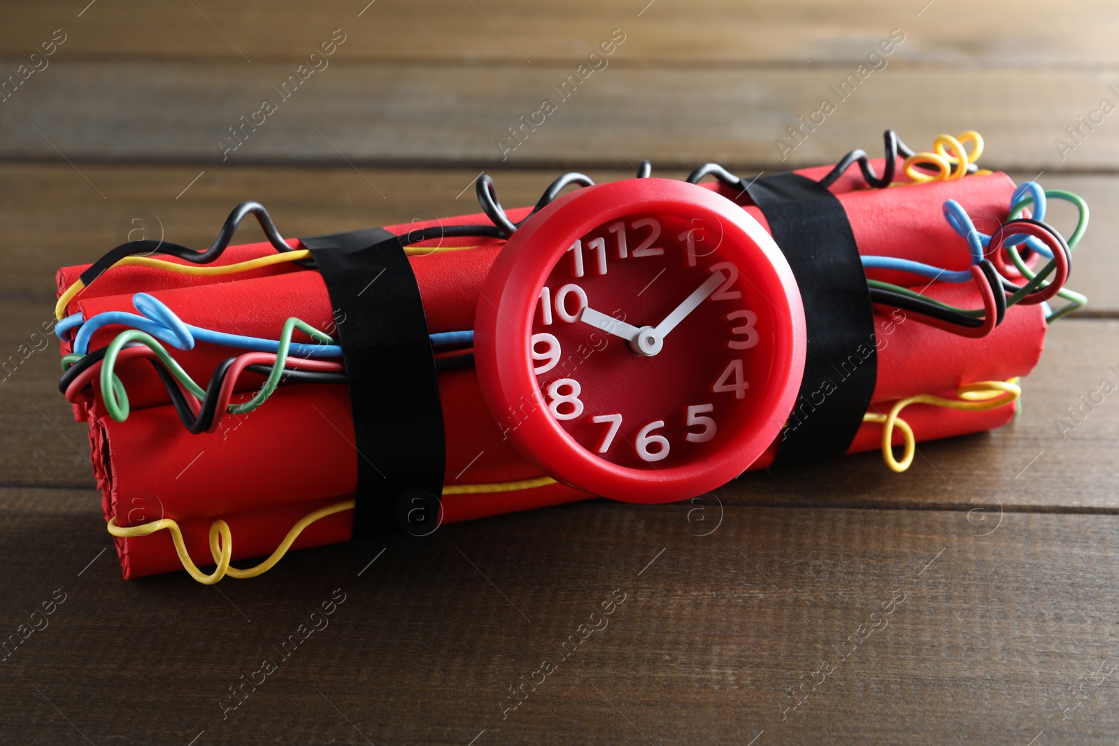 Photo of Dynamite time bomb on wooden table, closeup