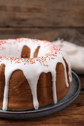 Glazed Easter cake with sprinkles on wooden table, closeup