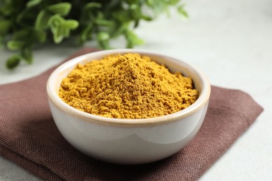 Curry powder in bowl on white table, closeup