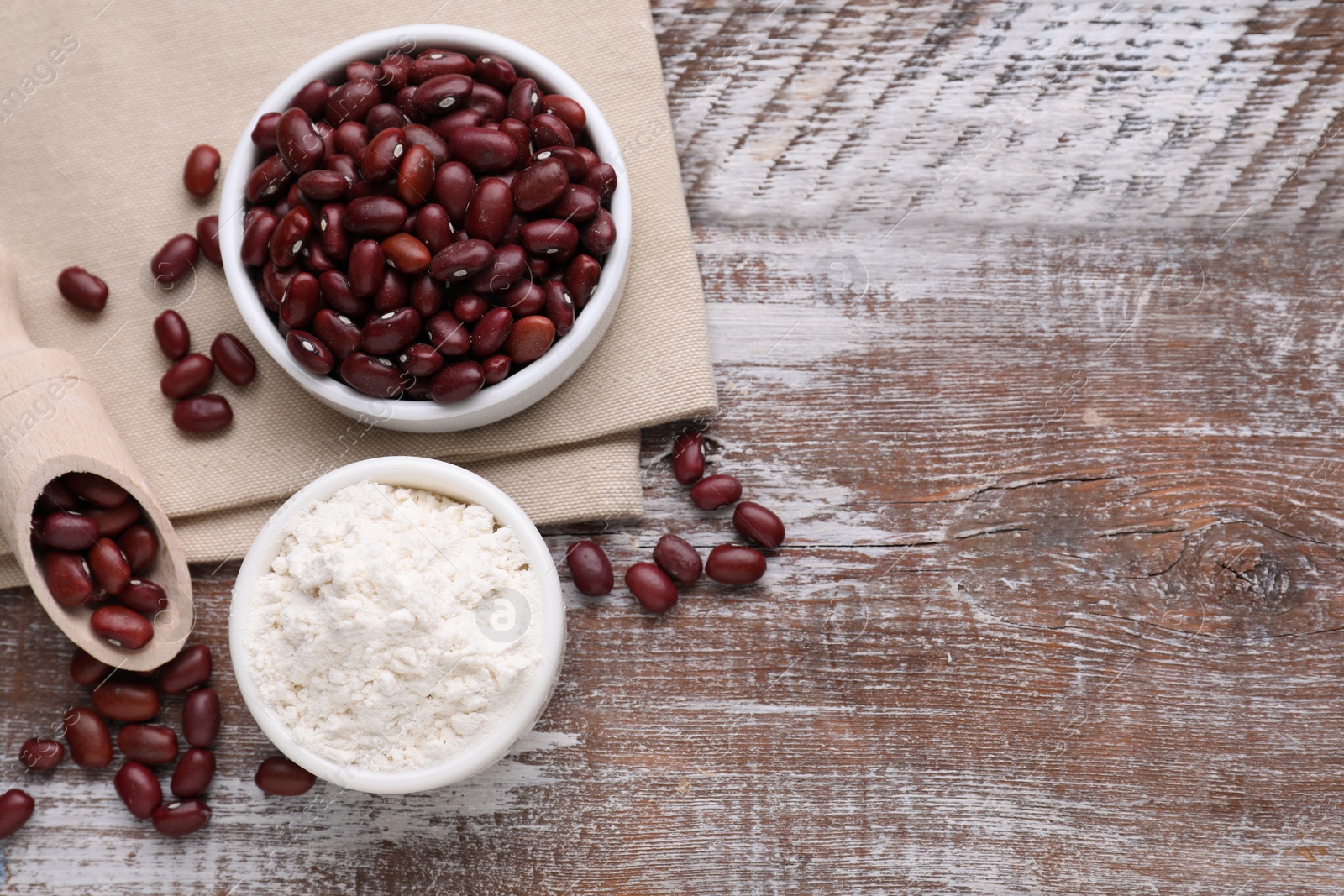 Photo of Kidney bean flour and seeds on wooden table, flat lay. Space for text