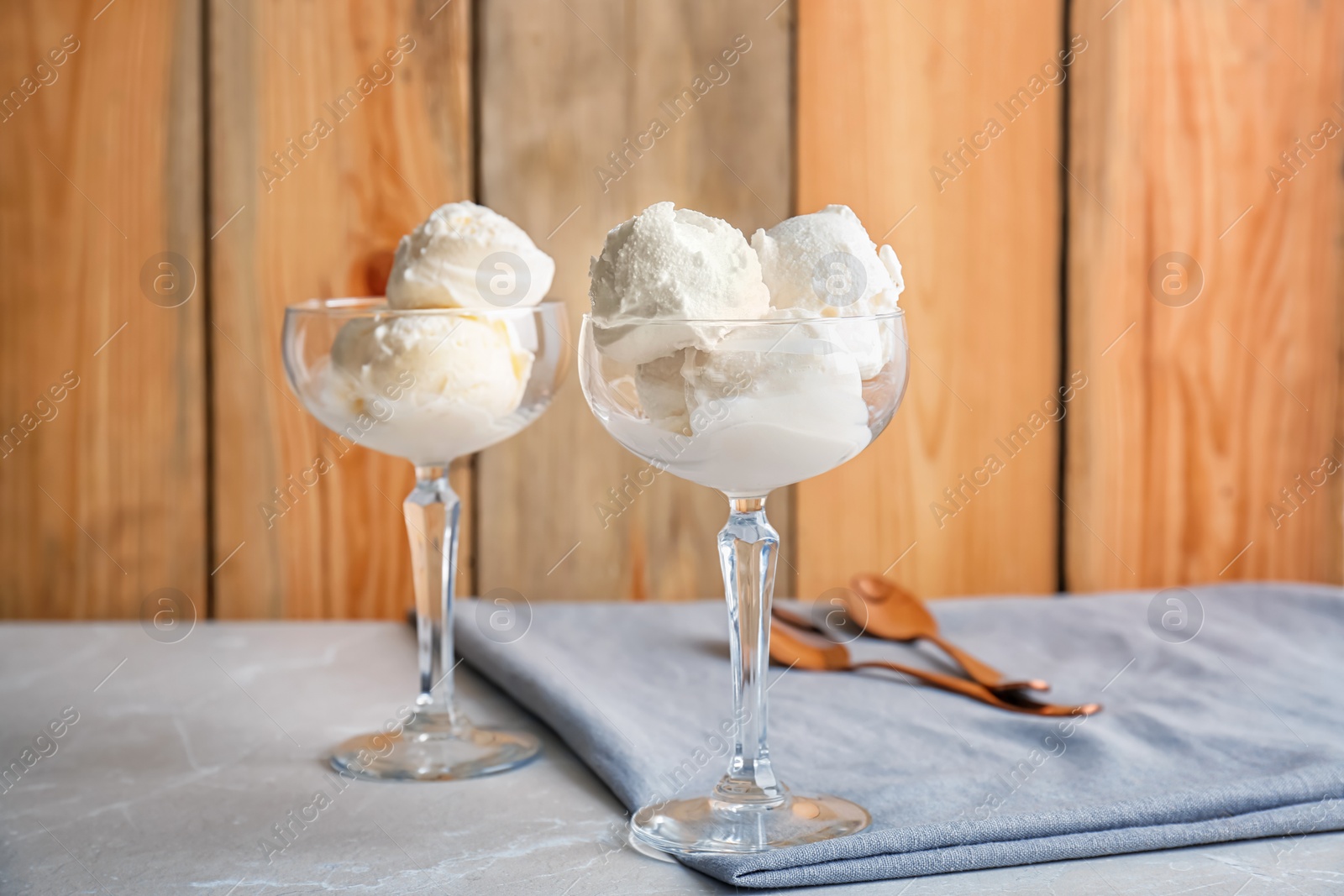 Photo of Bowls with tasty vanilla ice cream on table