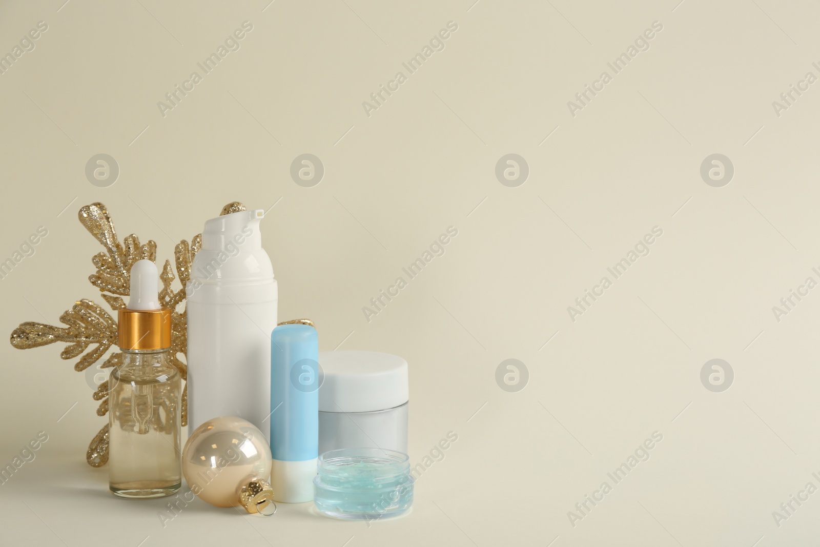 Photo of Beautiful composition with cosmetic products on beige background, space for text. Winter care