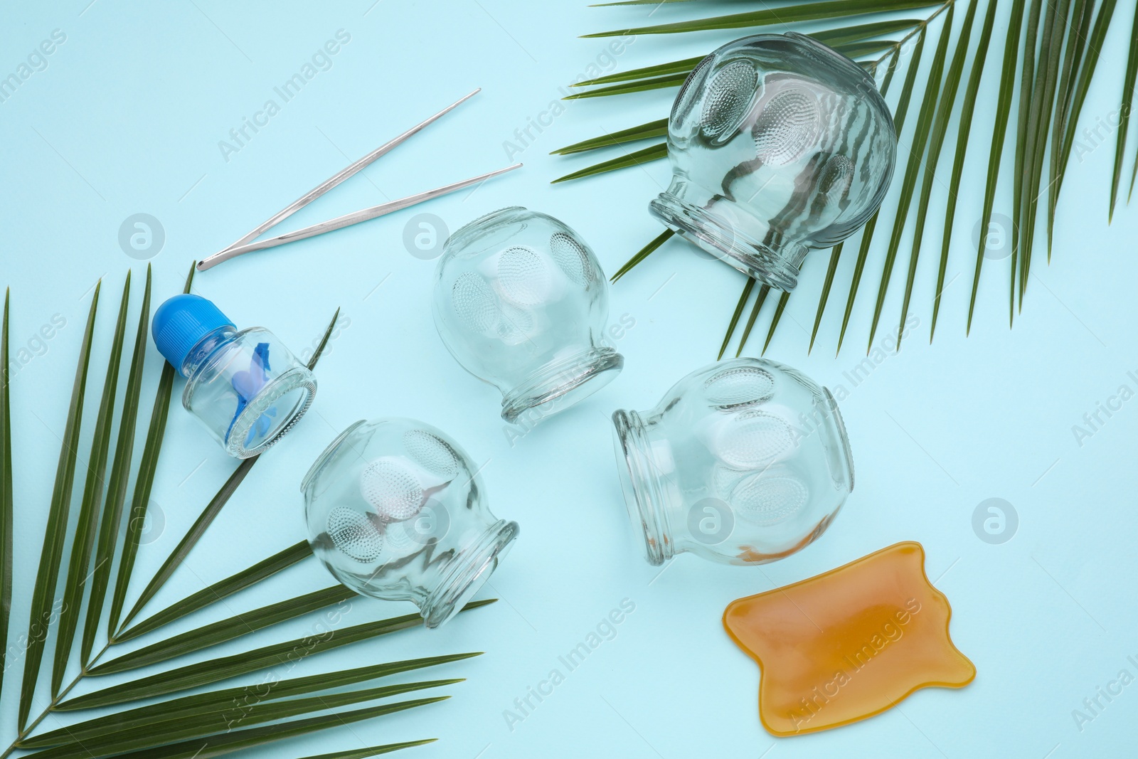 Photo of Flat lay composition with glass cups on light blue background. Cupping therapy