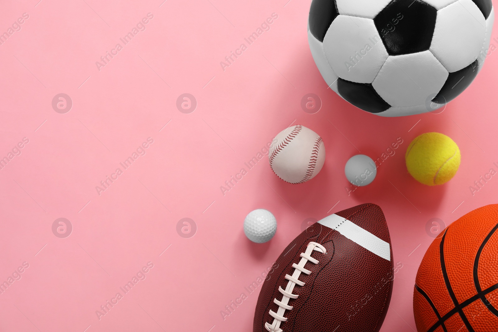 Photo of Many different sports balls on pink background, flat lay. Space for text