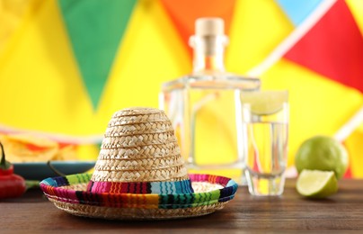 Mexican sombrero hat and tequila on wooden table