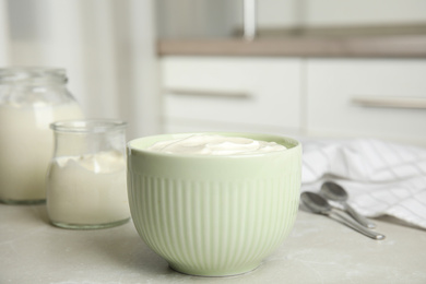 Photo of Tasty organic yogurt on grey table indoors