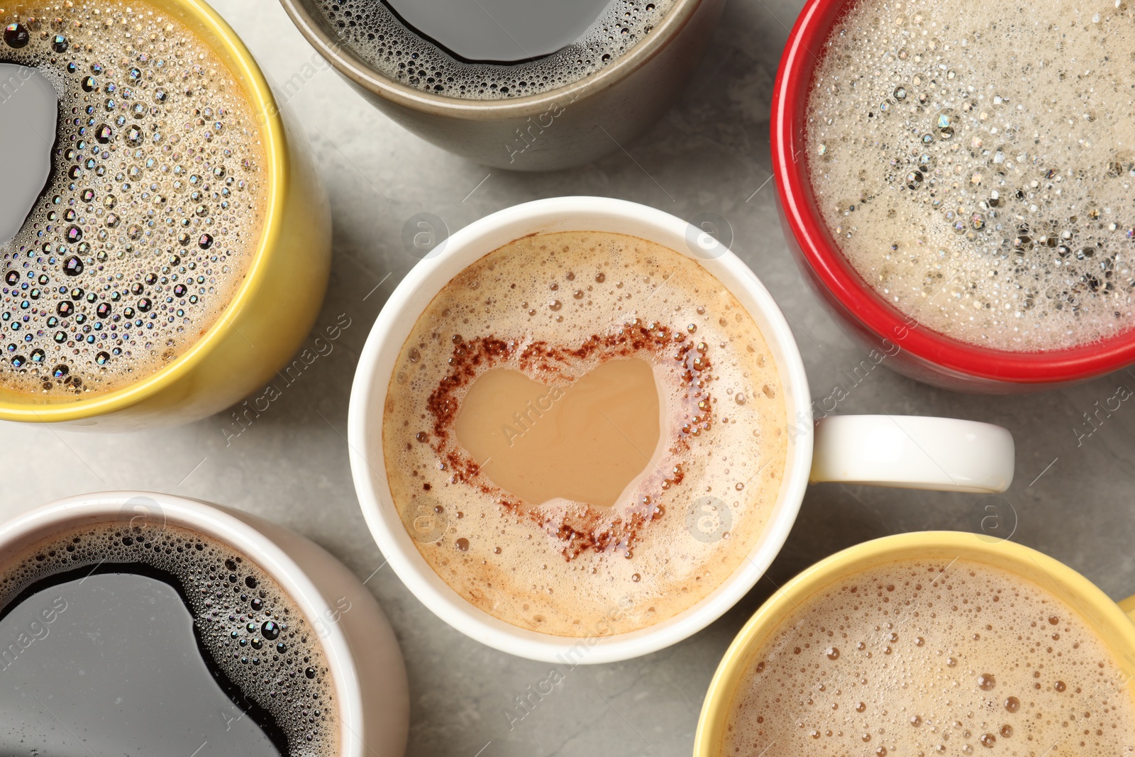 Photo of Many cups with different aromatic coffee on light grey table, flat lay