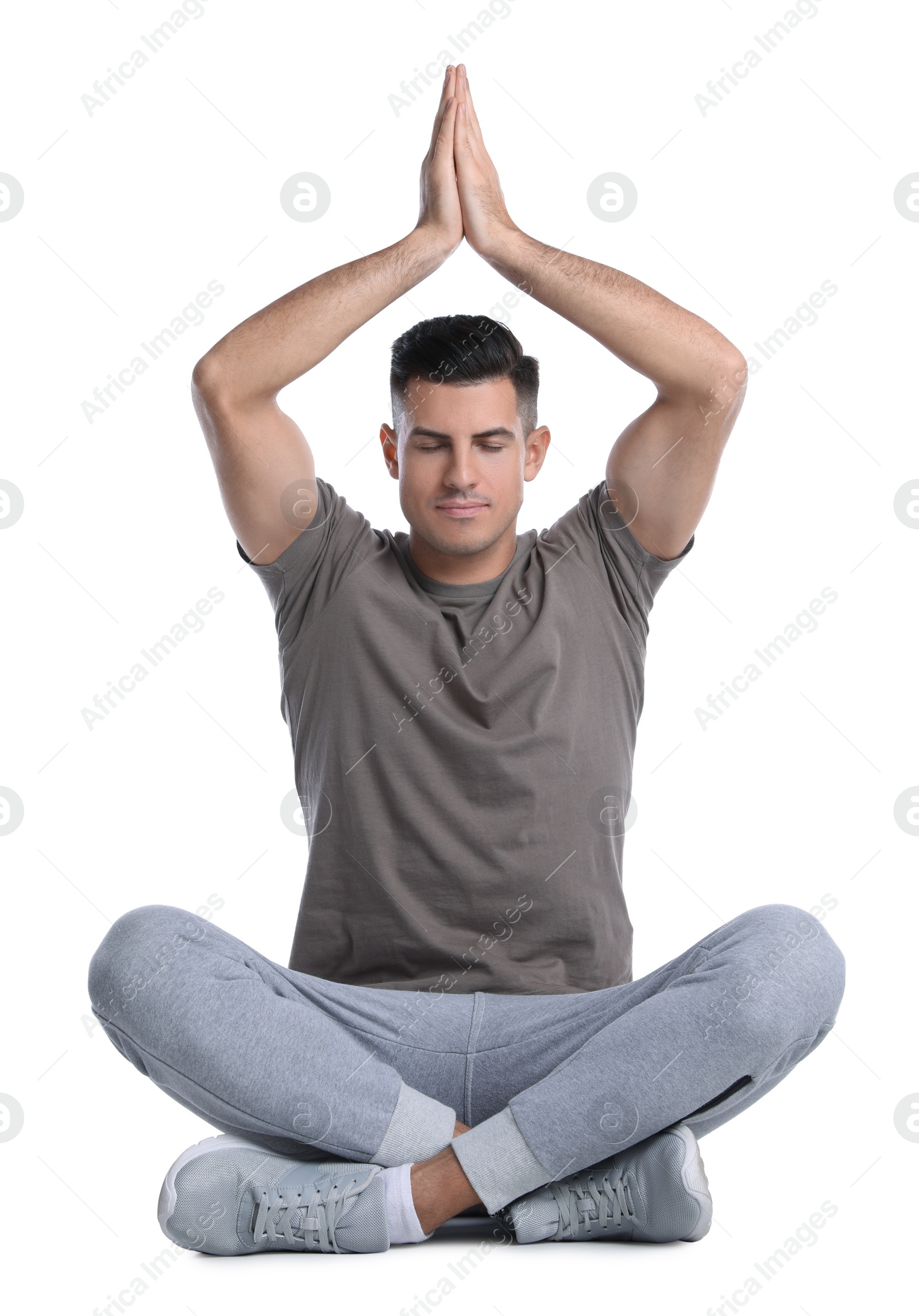 Photo of Handsome man meditating on white background. Harmony and zen