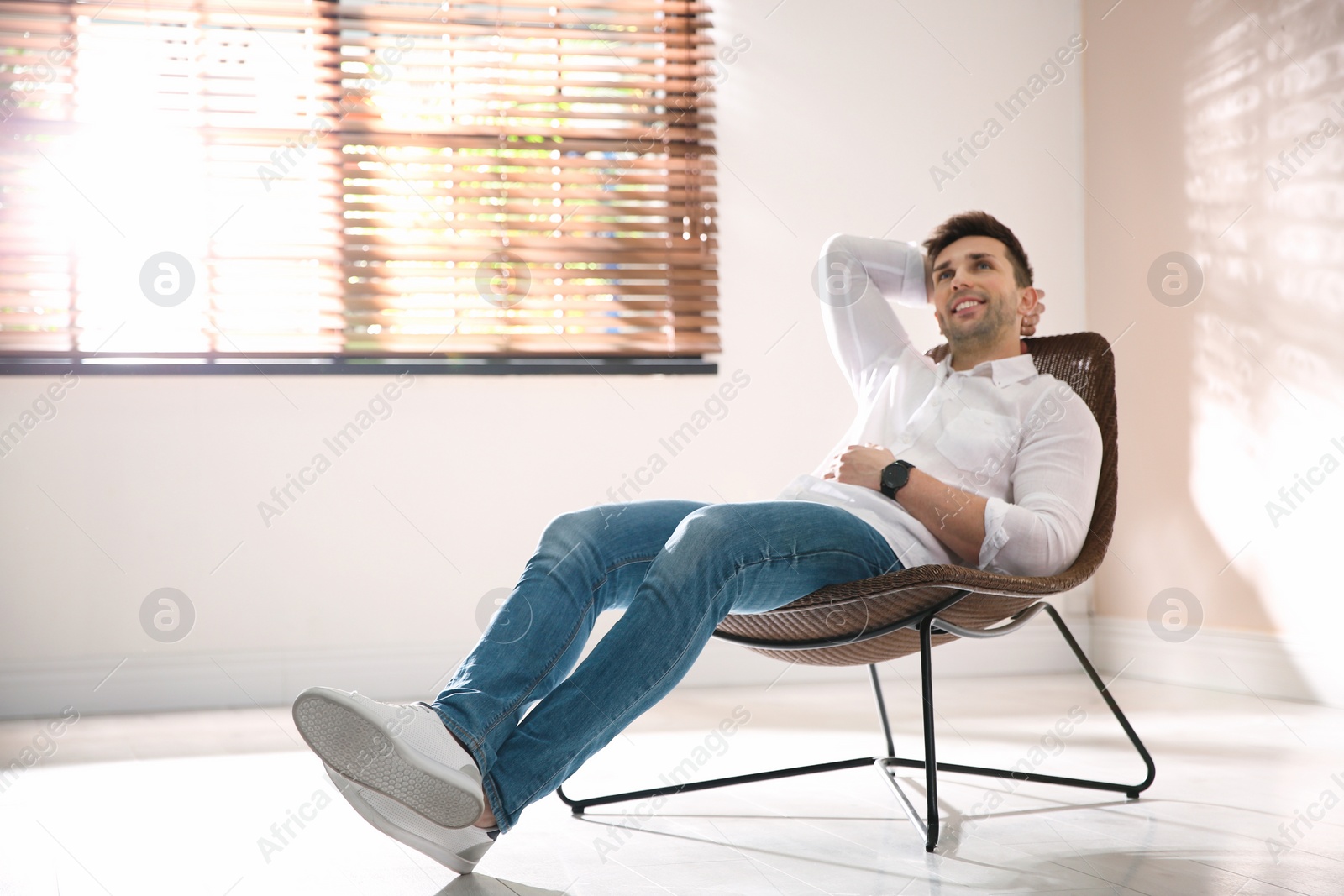 Photo of Young man relaxing near window at home. Space for text