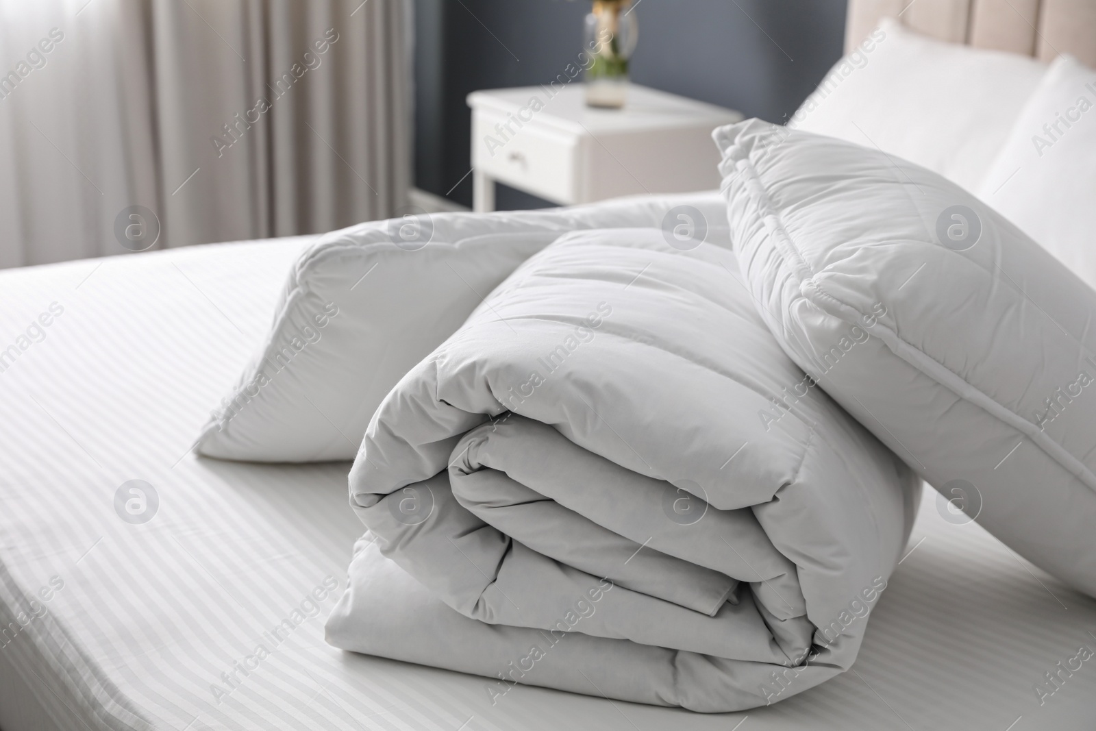 Photo of Soft folded blanket and pillows on bed indoors