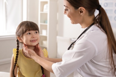 Photo of Doctor examining adorable child in hospital office