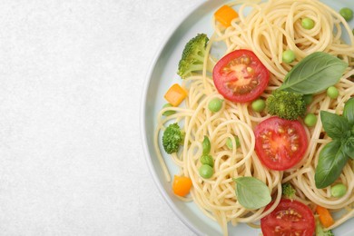 Photo of Plate of delicious pasta primavera on light gray table, top view. Space for text