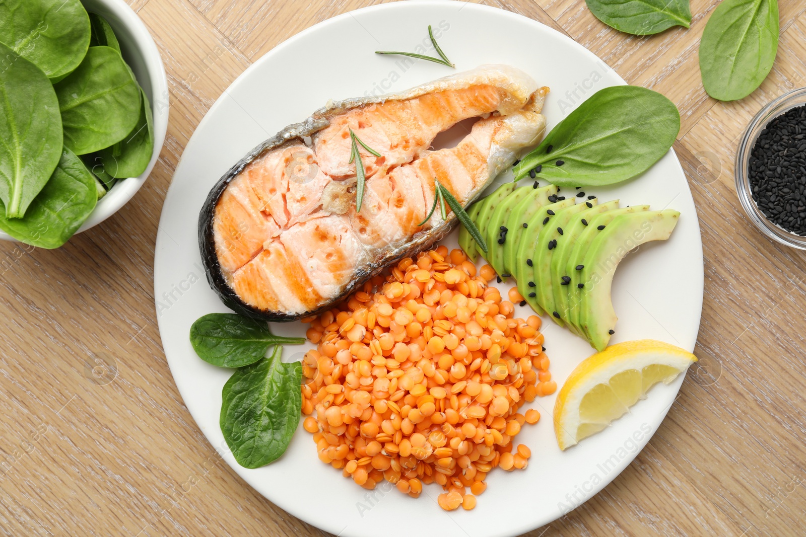 Photo of Plate with healthy food high in vegetable fats on wooden table, flat lay