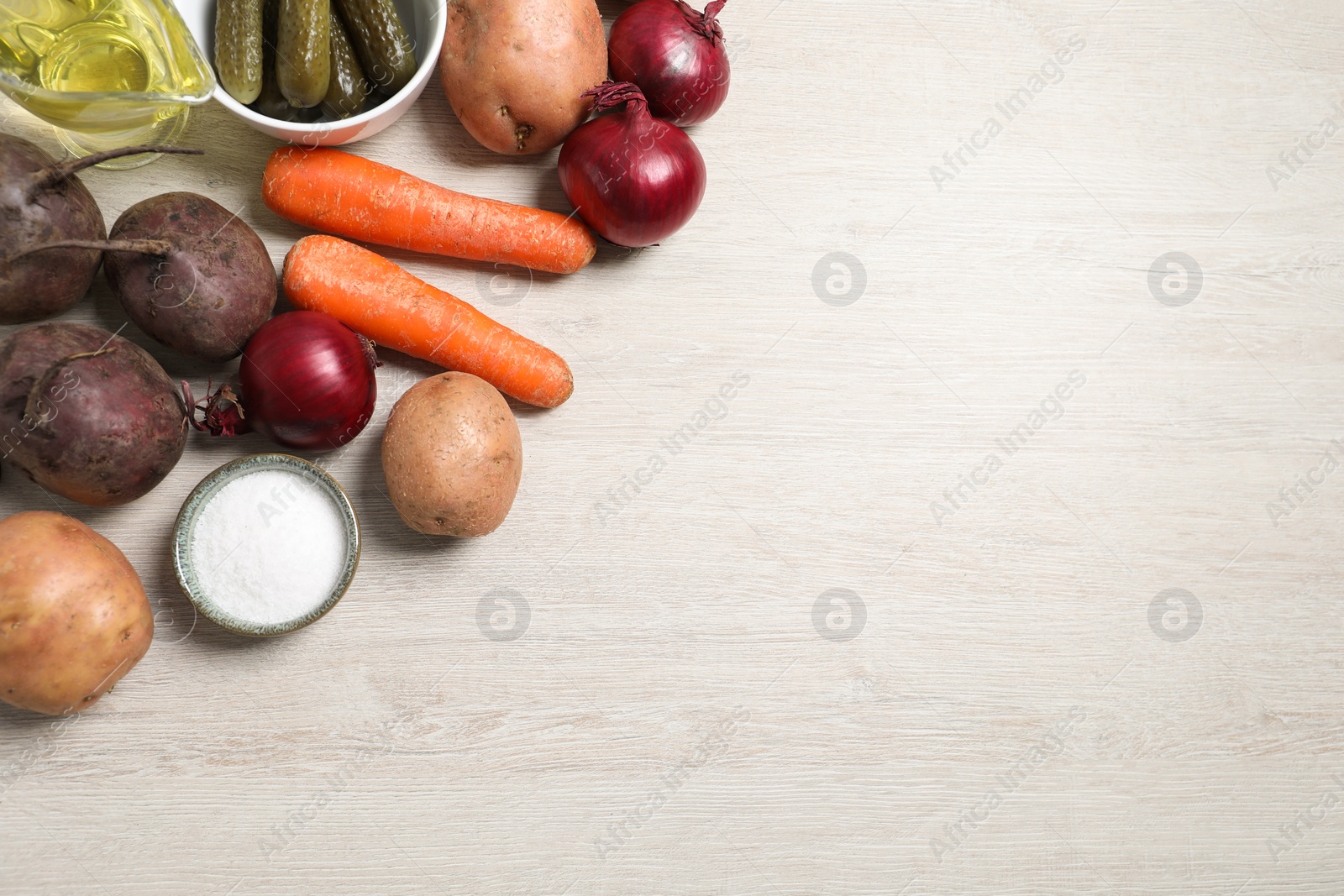 Photo of Many fresh vegetables and other ingredients on white wooden table, flat lay with space for text. Cooking vinaigrette salad