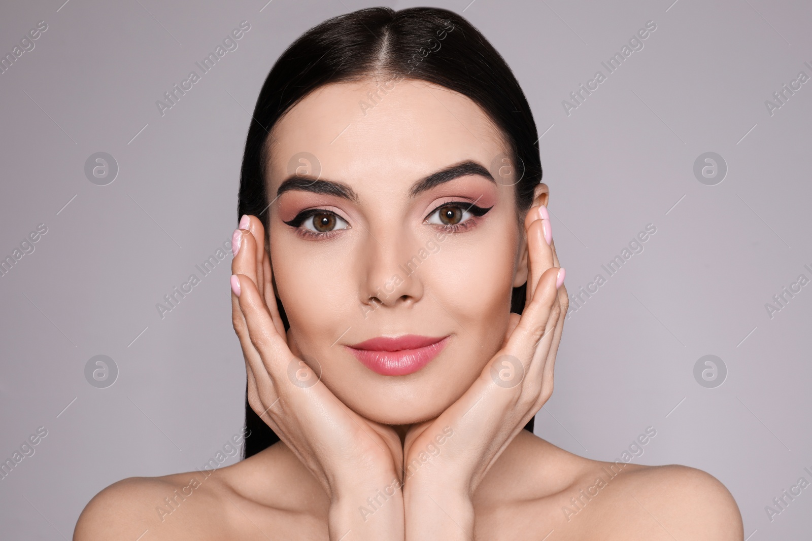 Photo of Beautiful woman with black eyeliner on grey background