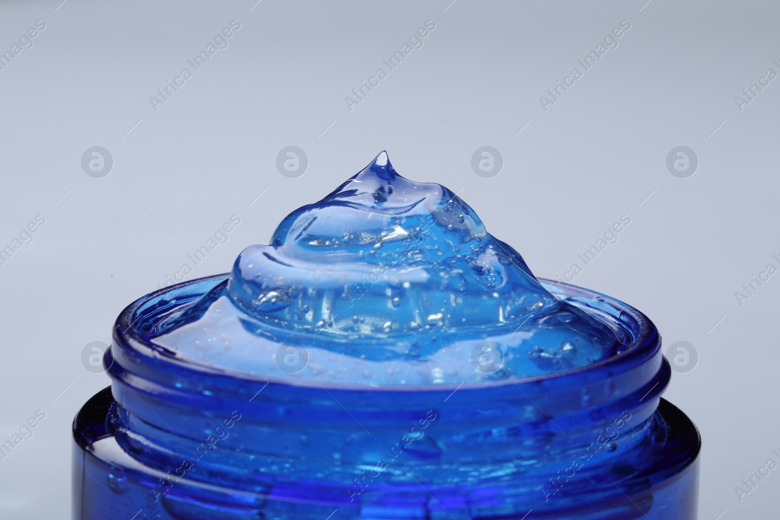 Photo of Jar of transparent cosmetic gel on light background, closeup