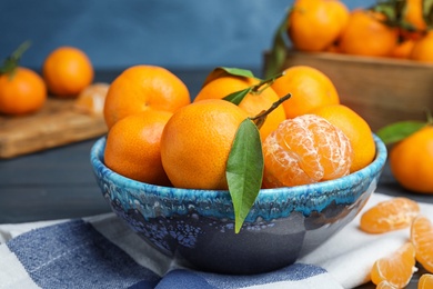 Photo of Fresh ripe tangerines in bowl on table