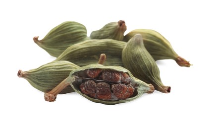 Pile of dry green cardamom pods on white background