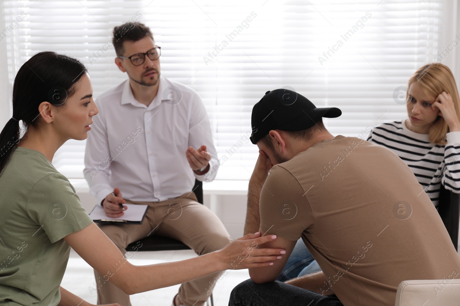 Photo of Psychotherapist working with group of drug addicted people at therapy session indoors