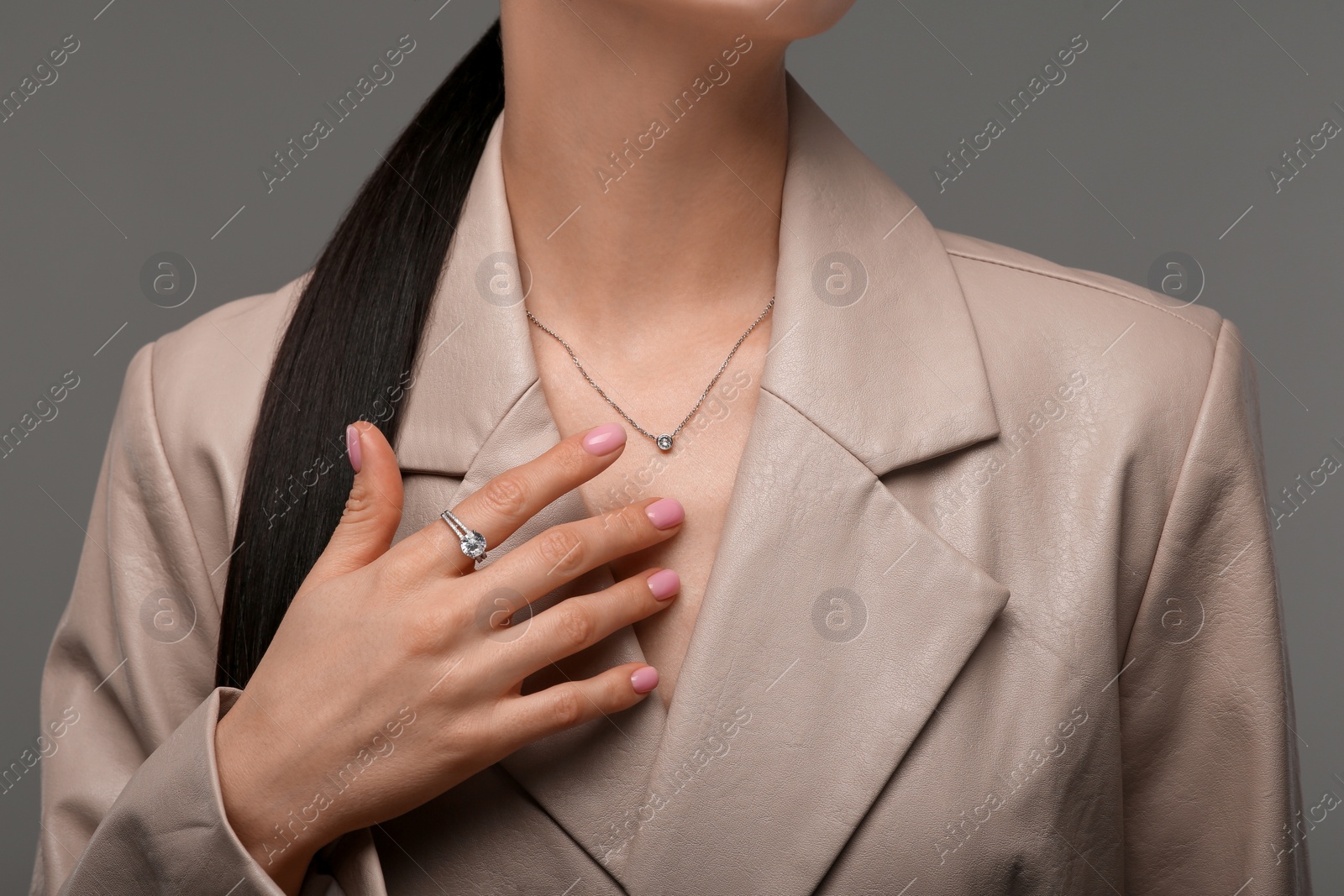 Photo of Young woman with elegant jewelry on dark grey background, closeup
