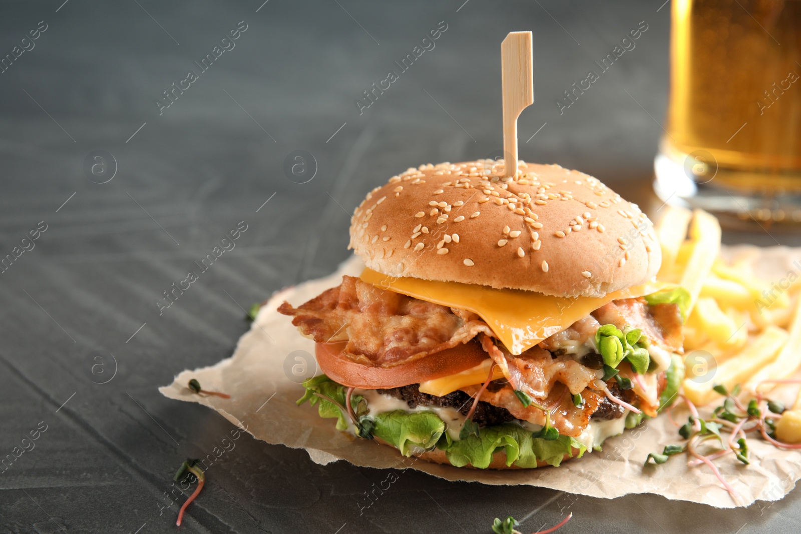 Photo of Tasty burger with bacon on table. Space for text