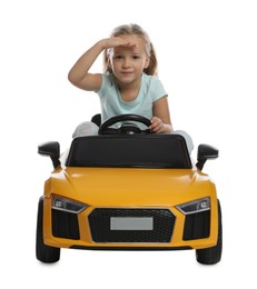 Photo of Cute little girl driving children's electric toy car on white background