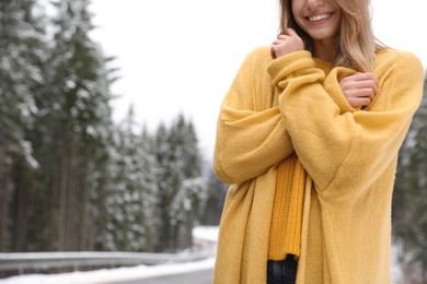 Young woman in warm clothes outdoors, closeup with space for text. Winter vacation