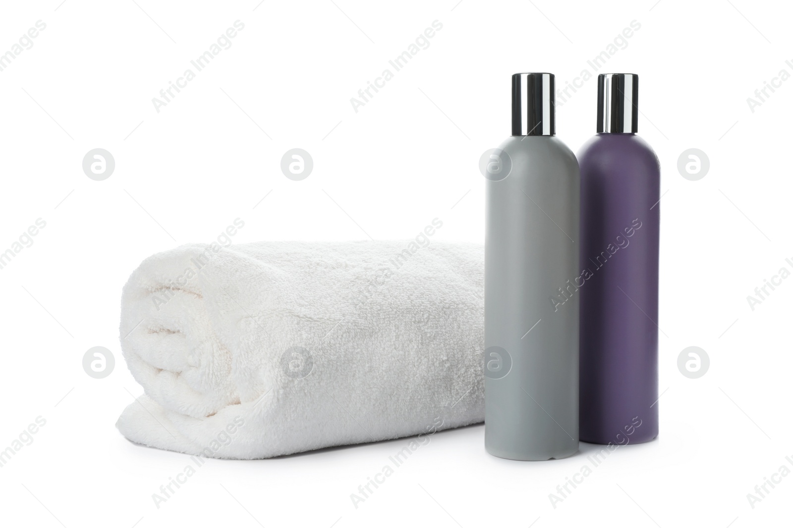 Photo of Rolled towel and shampoo isolated on white