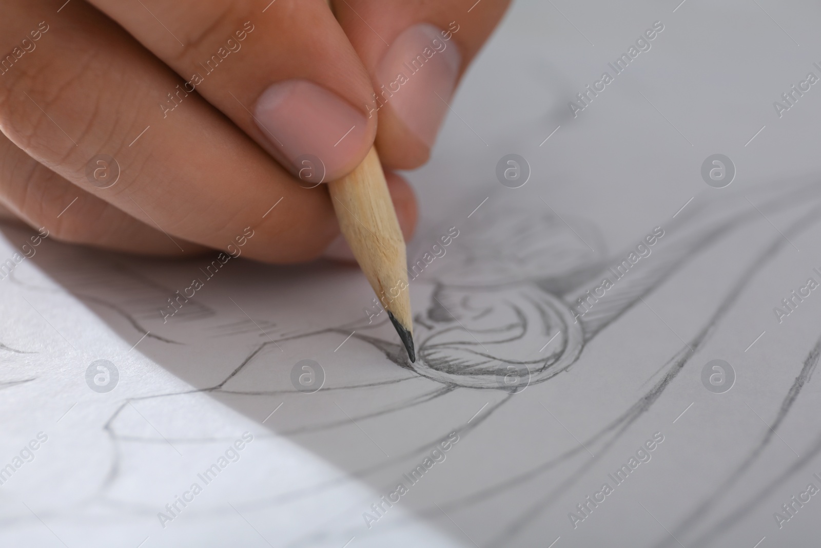 Photo of Man drawing portrait with pencil in notepad, closeup