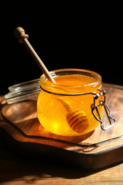 Fresh honey in jar on wooden table