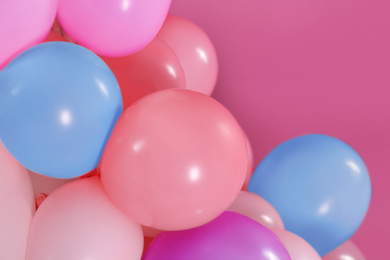 Beautiful colorful balloons on pink background, closeup. Party decor 