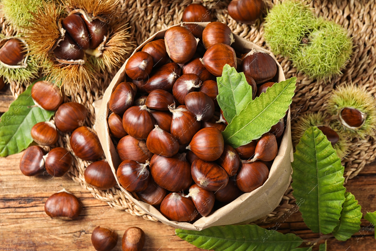 Photo of Fresh sweet edible chestnuts on wooden table, flat lay