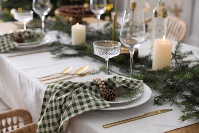 Photo of Christmas table setting with festive decor and dishware indoors