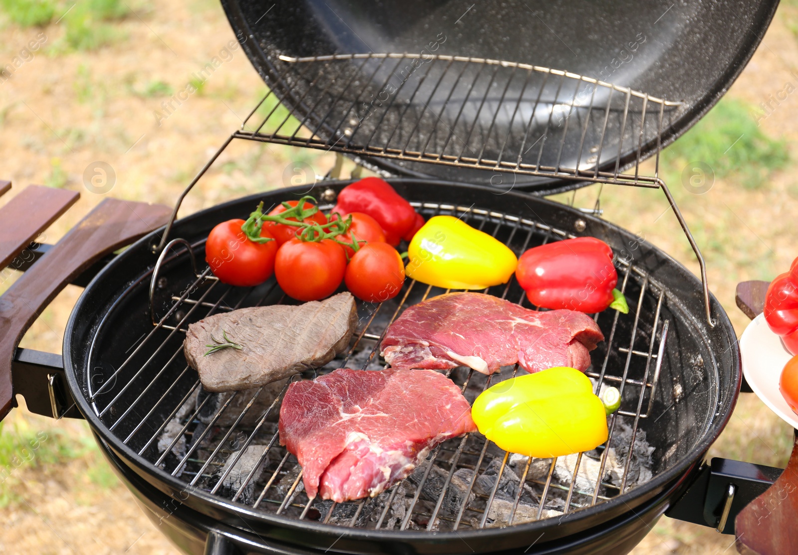 Photo of Modern grill with meat and vegetables outdoors, closeup