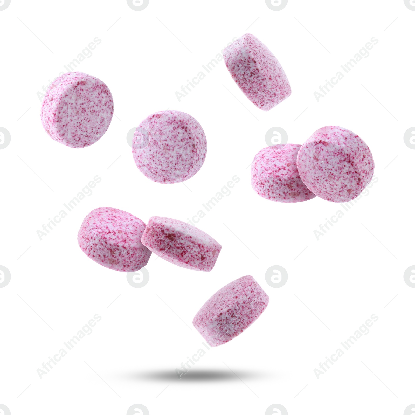 Image of Vitamin. Pink tablets falling on white background