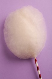 Photo of One sweet cotton candy on violet background, top view