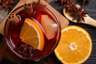 Glass of aromatic punch drink and ingredients on table, flat lay