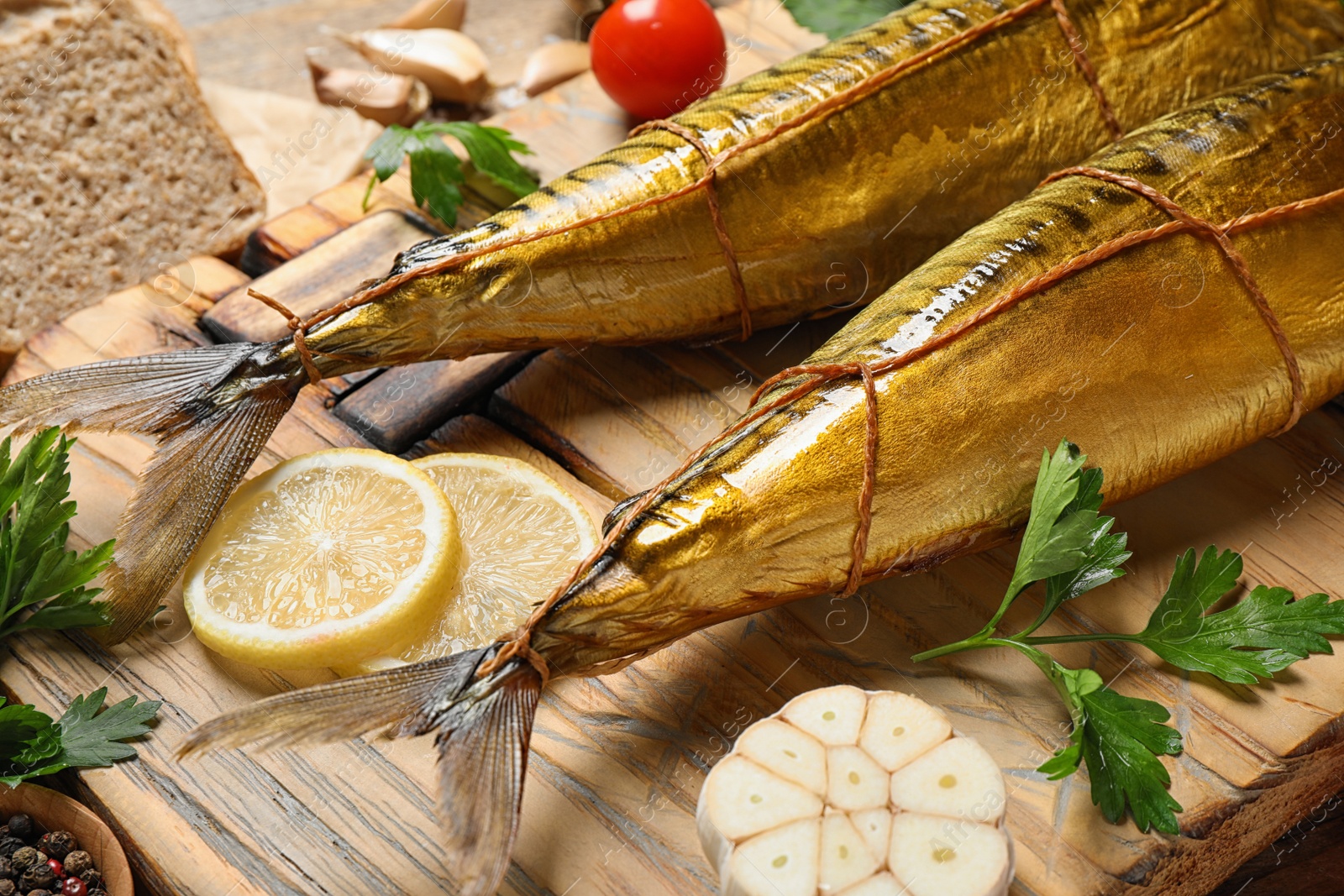 Photo of Tasty smoked fish served on table, closeup