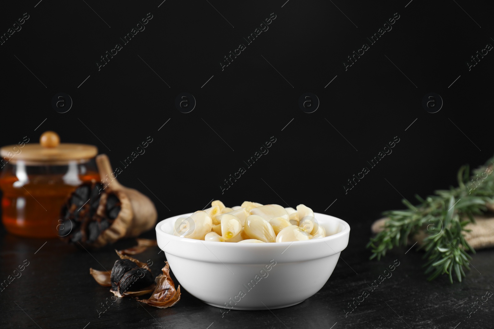 Photo of Fresh and fermented black garlic on table. Space for text