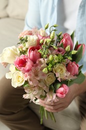 Man holding bouquet of beautiful flowers indoors, closeup