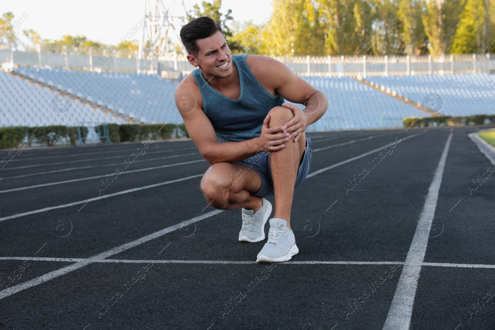 Photo of Man in sportswear having knee problems at stadium